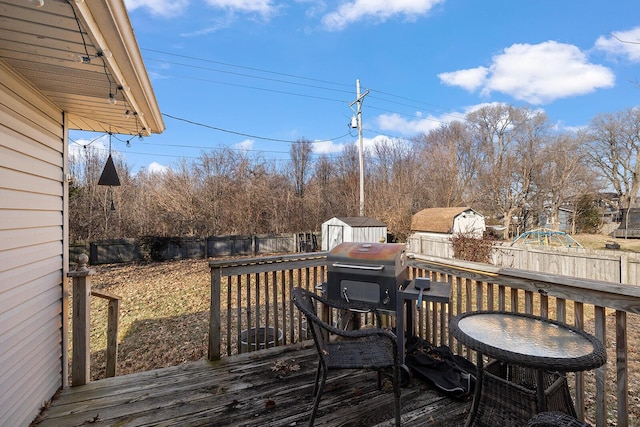 wooden deck featuring a grill and a storage unit