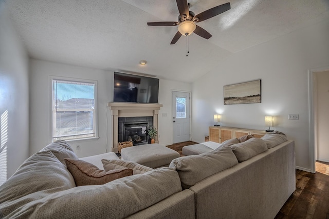 living room featuring lofted ceiling, dark hardwood / wood-style floors, a fireplace, and a textured ceiling