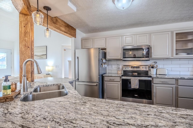 kitchen featuring light stone countertops, appliances with stainless steel finishes, sink, and decorative backsplash