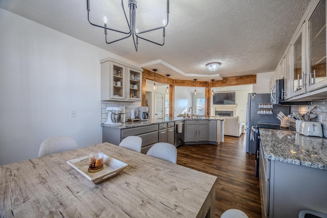 kitchen featuring gray cabinets, pendant lighting, decorative backsplash, stainless steel appliances, and a textured ceiling