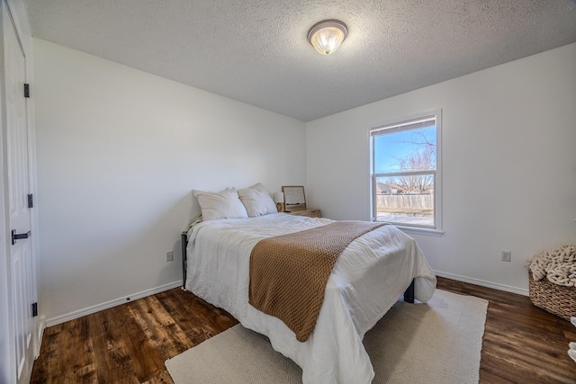 bedroom featuring a textured ceiling and dark hardwood / wood-style flooring