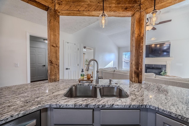 kitchen featuring gray cabinets, vaulted ceiling, sink, ceiling fan, and a textured ceiling