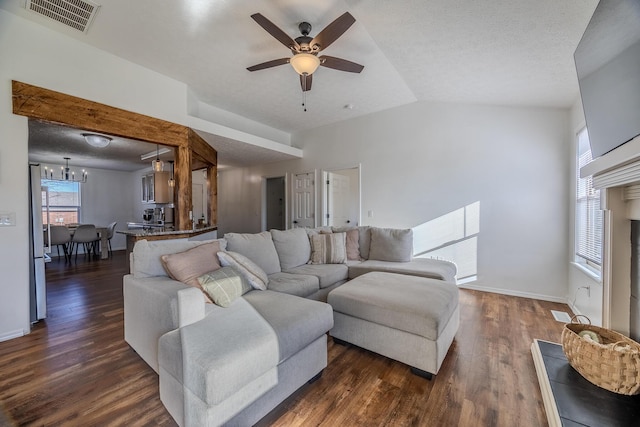 living room featuring ceiling fan with notable chandelier, dark wood-type flooring, a textured ceiling, and vaulted ceiling