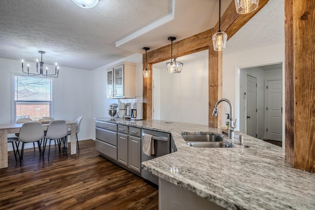 kitchen featuring sink, a textured ceiling, dark hardwood / wood-style floors, dishwasher, and light stone countertops