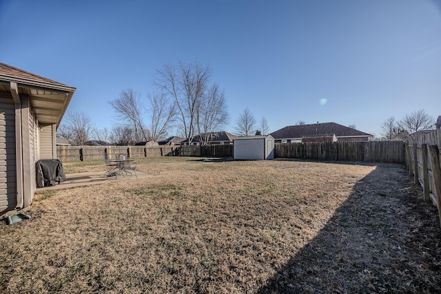 view of yard with a storage shed and a patio area