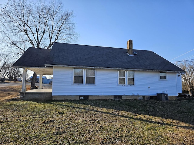 back of house with central AC and a lawn