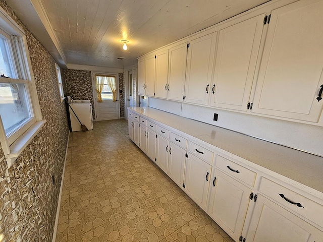 kitchen featuring wood ceiling and white cabinets