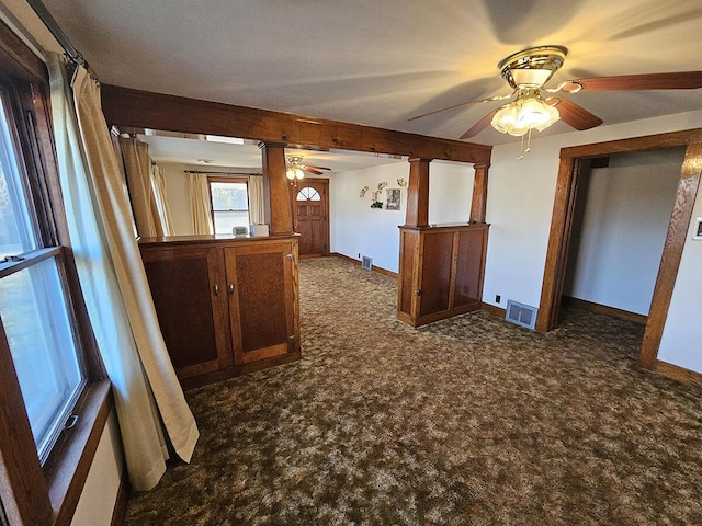 spare room with ceiling fan and dark colored carpet