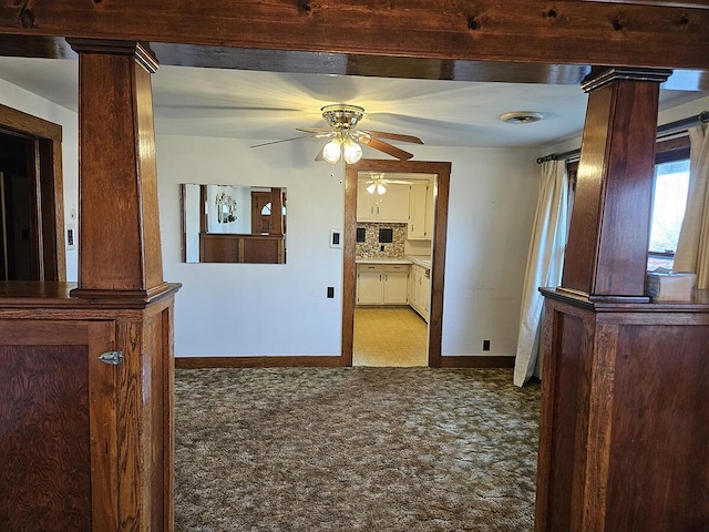 hallway featuring decorative columns and light carpet