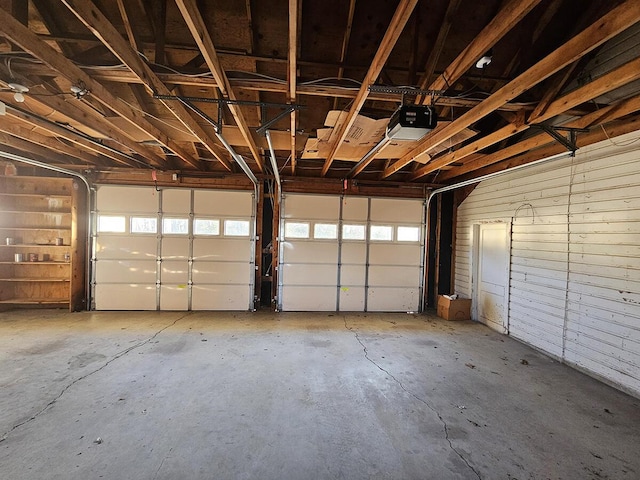 garage with a garage door opener and wooden walls