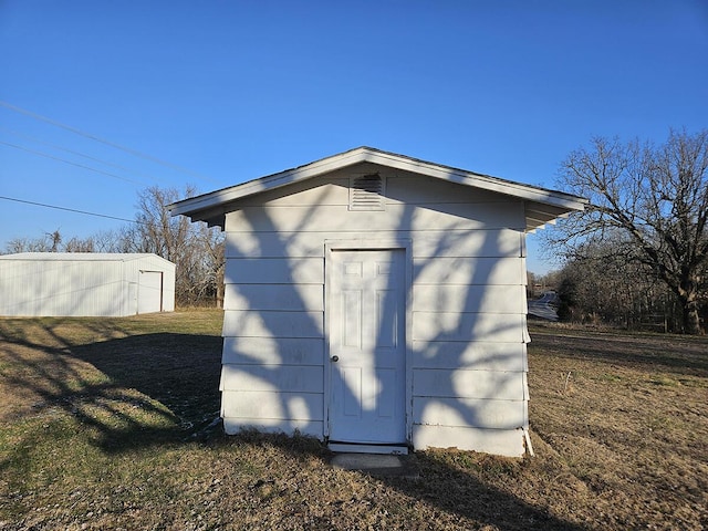 view of outdoor structure featuring a lawn