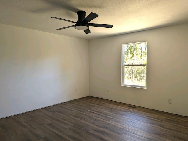 spare room with dark wood-type flooring, ceiling fan, and a textured ceiling