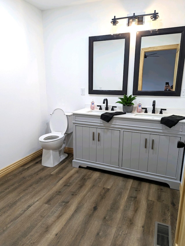 bathroom featuring vanity, hardwood / wood-style flooring, and toilet