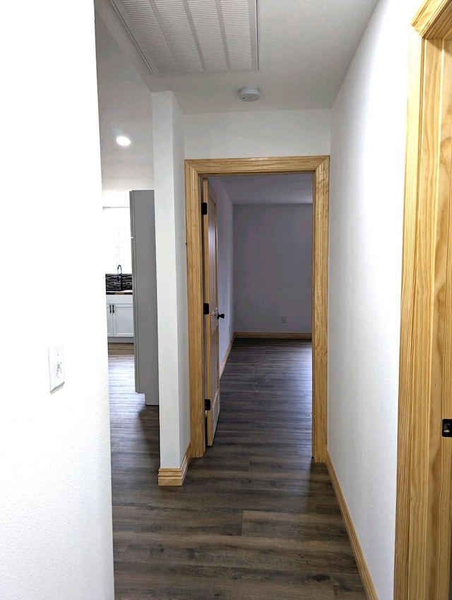 corridor with dark hardwood / wood-style floors and sink