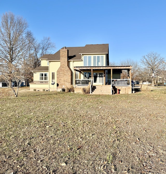 rear view of house with covered porch and a lawn