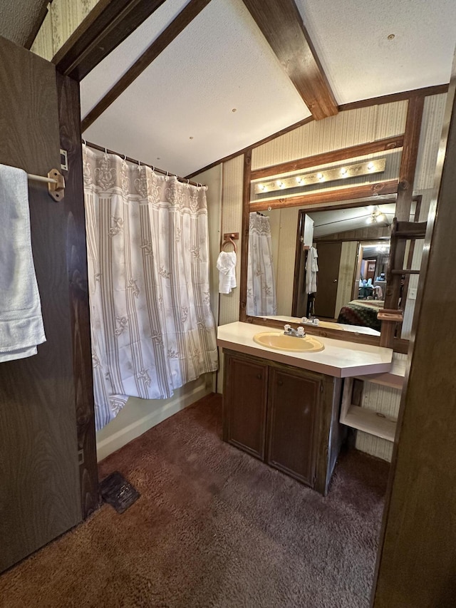 bathroom with wooden walls, vaulted ceiling with beams, vanity, shower / bathtub combination with curtain, and a textured ceiling