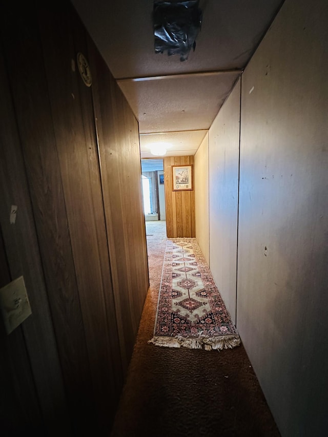 hall with carpet and wood walls