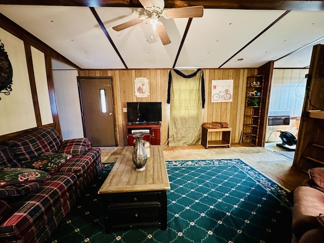 carpeted living room with ceiling fan and wood walls