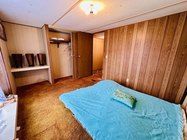 carpeted bedroom featuring wooden walls and a closet