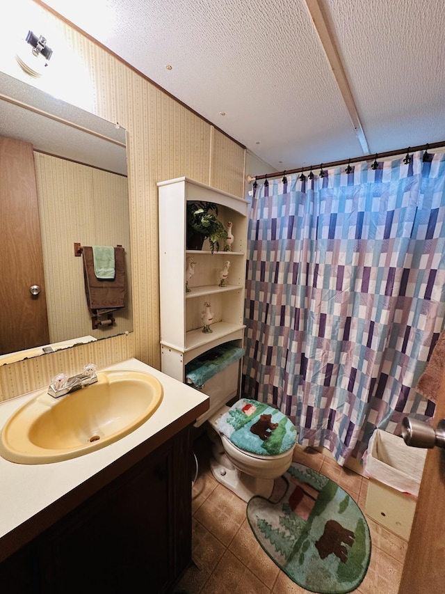 bathroom featuring vanity, tile patterned floors, a textured ceiling, and toilet