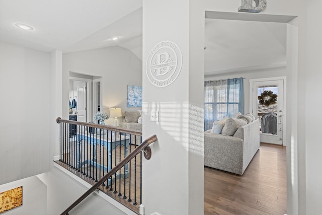 hall with vaulted ceiling and hardwood / wood-style floors