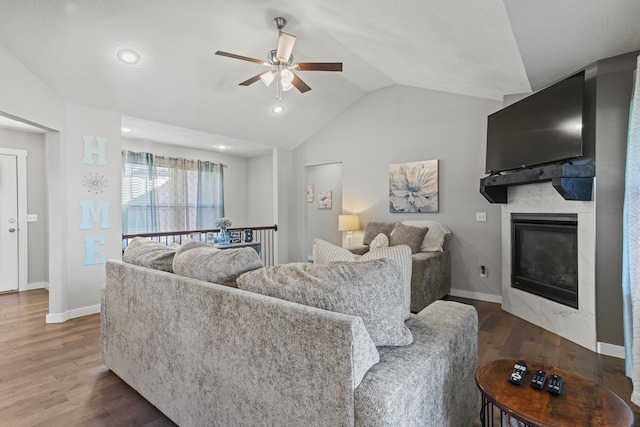 living room with lofted ceiling, a fireplace, dark wood-type flooring, and ceiling fan