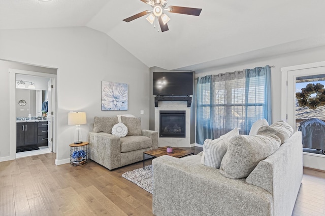 living room featuring vaulted ceiling, ceiling fan, and light wood-type flooring