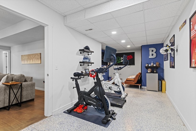 exercise room featuring hardwood / wood-style floors and a drop ceiling