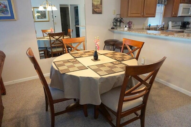 carpeted dining room featuring a chandelier