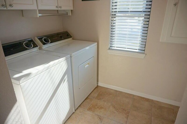 washroom featuring washer and clothes dryer, cabinets, and a healthy amount of sunlight