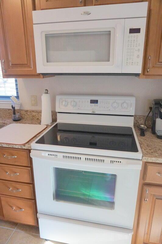 kitchen featuring light tile patterned flooring and white appliances