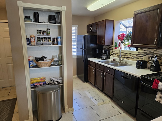 kitchen featuring sink, light tile patterned floors, a healthy amount of sunlight, decorative backsplash, and black appliances