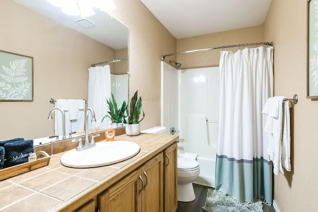 full bathroom featuring vanity, shower / bath combination with curtain, and toilet