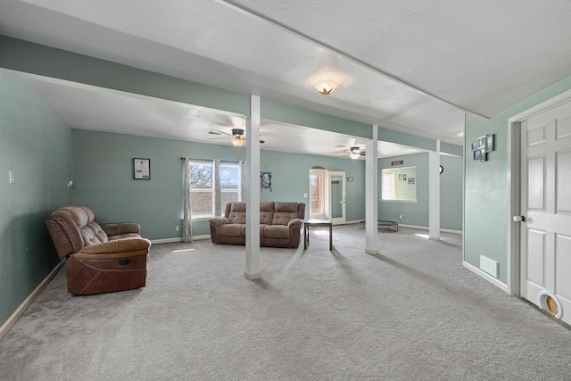 carpeted living room featuring ceiling fan and a textured ceiling