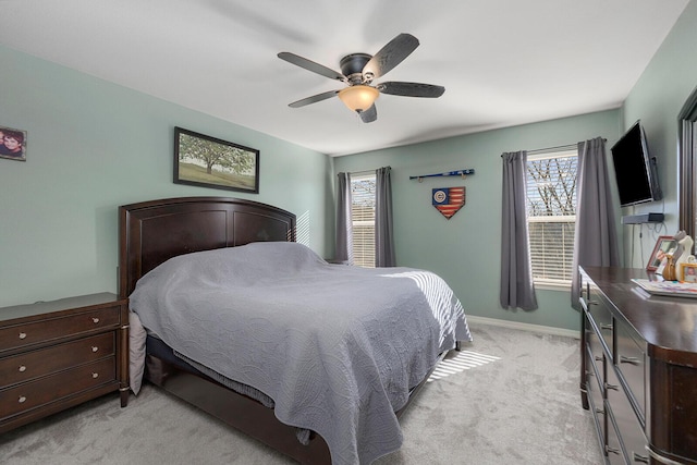 bedroom with ceiling fan, light colored carpet, and multiple windows