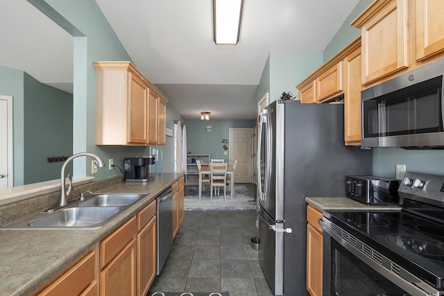 kitchen featuring appliances with stainless steel finishes, light brown cabinetry, and sink