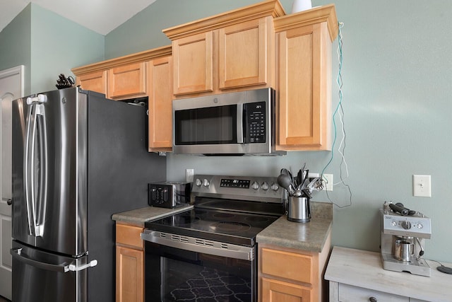 kitchen featuring lofted ceiling and appliances with stainless steel finishes