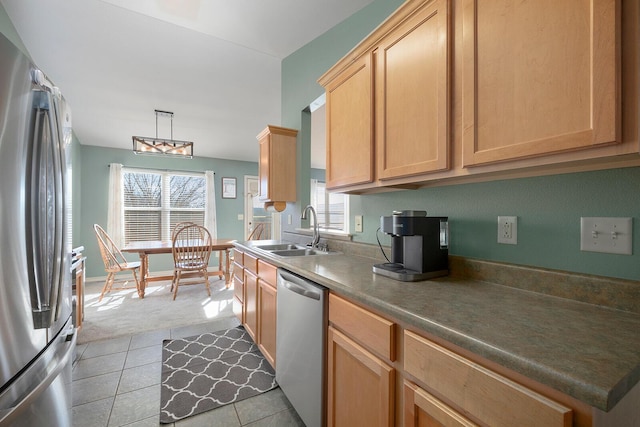 kitchen featuring sink, light tile patterned floors, appliances with stainless steel finishes, hanging light fixtures, and light brown cabinets