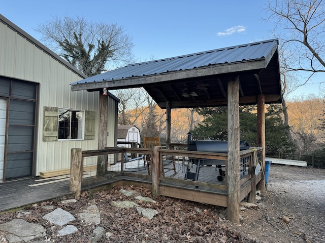 wooden terrace with a gazebo and a shed