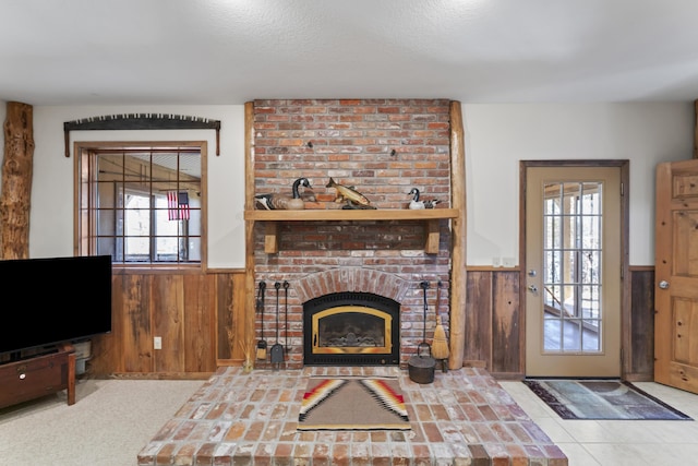 living room with a textured ceiling, a fireplace, and wooden walls