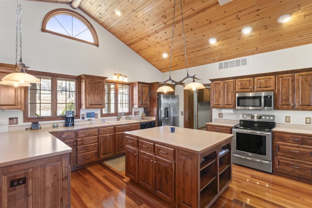 kitchen with sink, stainless steel appliances, a kitchen island, decorative light fixtures, and wooden ceiling