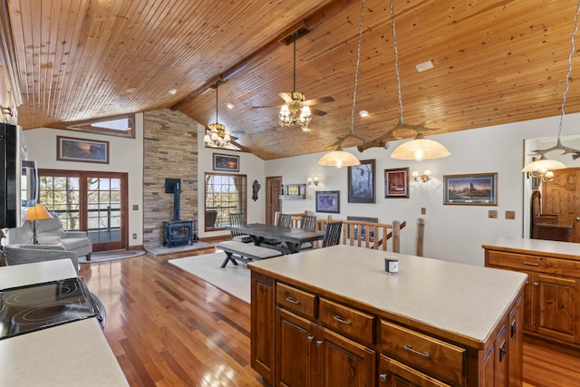 kitchen with high vaulted ceiling, hanging light fixtures, wooden ceiling, a kitchen island, and beamed ceiling