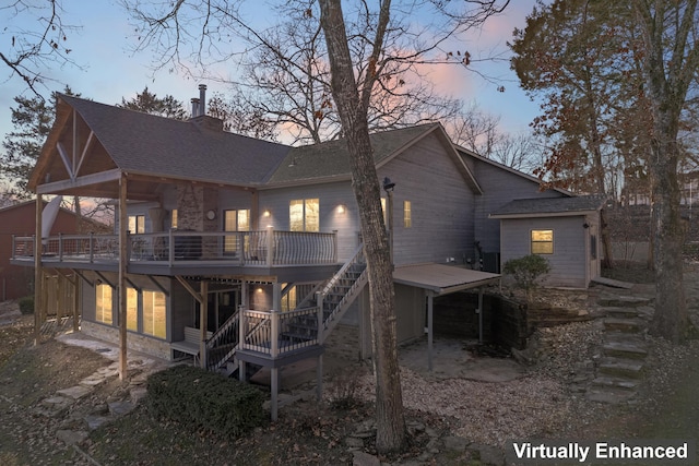 back house at dusk with a wooden deck