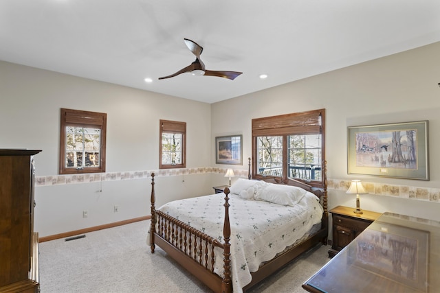 carpeted bedroom featuring ceiling fan and multiple windows