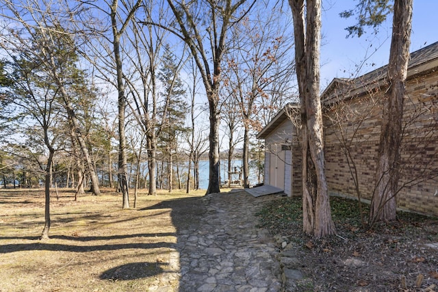 view of yard with a water view and a storage shed