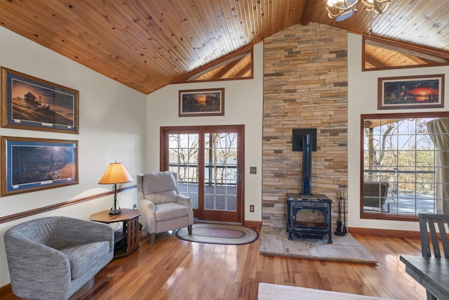 living area featuring wood-type flooring, a wood stove, wooden ceiling, and high vaulted ceiling