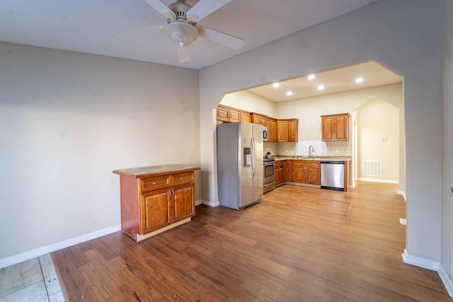 kitchen featuring light hardwood / wood-style floors, ceiling fan, and appliances with stainless steel finishes