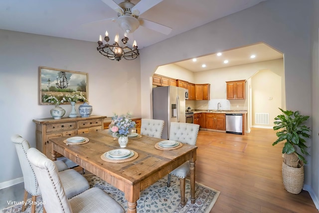 dining space with ceiling fan and light wood-type flooring