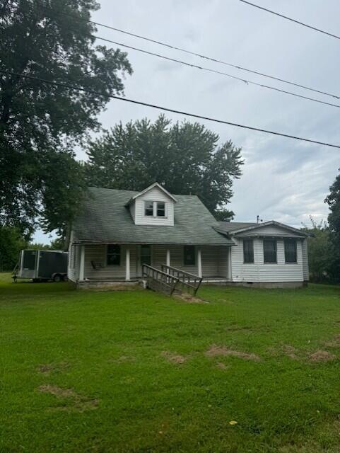 back of property with a yard and covered porch