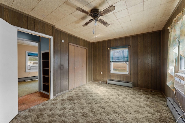 interior space featuring a baseboard heating unit, a closet, ceiling fan, and carpet